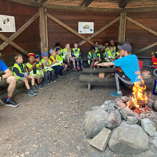 Barn og voksne i gapahuk med bål